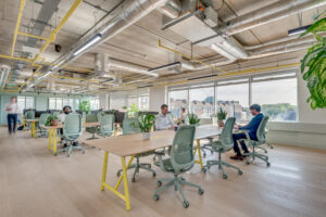 People sat at desks, enjoying the well lit Huddle Hammersmith Coworking Space