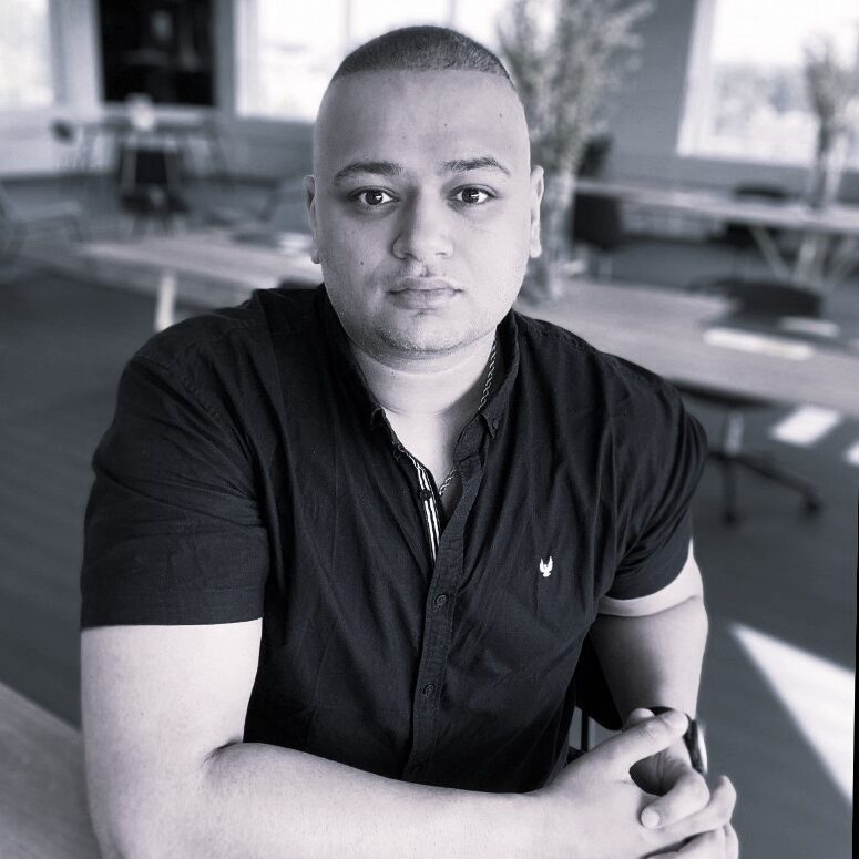 Photograph of Amar Shah sitting at a table in Huddle Shortlands